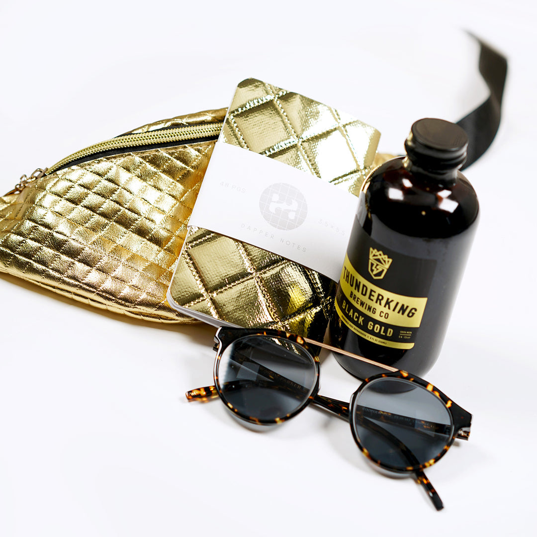 GOLD fanny pack, pocket notebook, warby parker cooper frames, and thunderking brewing black cold brew coffee