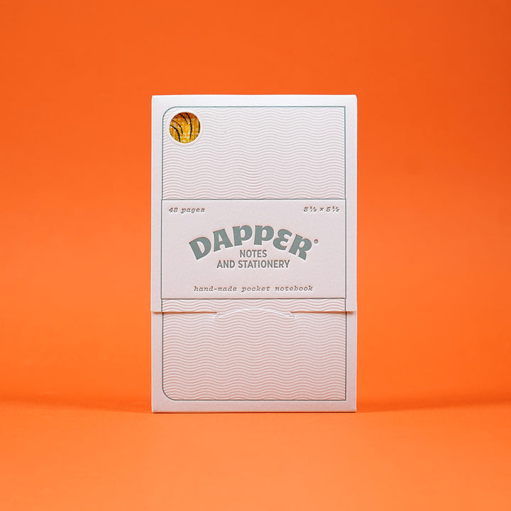 letterpress notebook packaging by mama's sauce for dapper notes, featuring dylan goldberger's notebook inside, visible through a small cutout