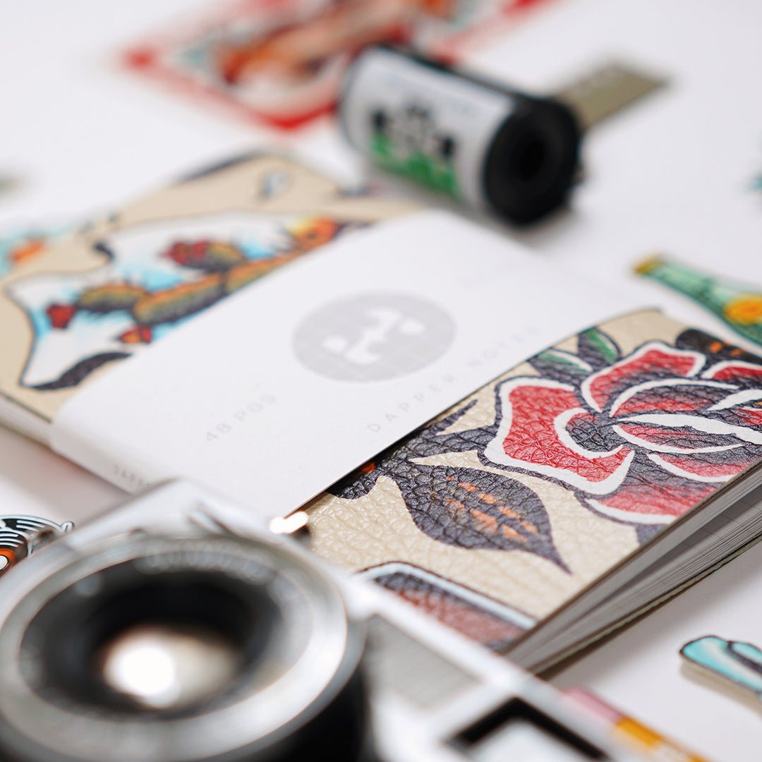 tattoo notebook, ilford hp5 film, and camera lens