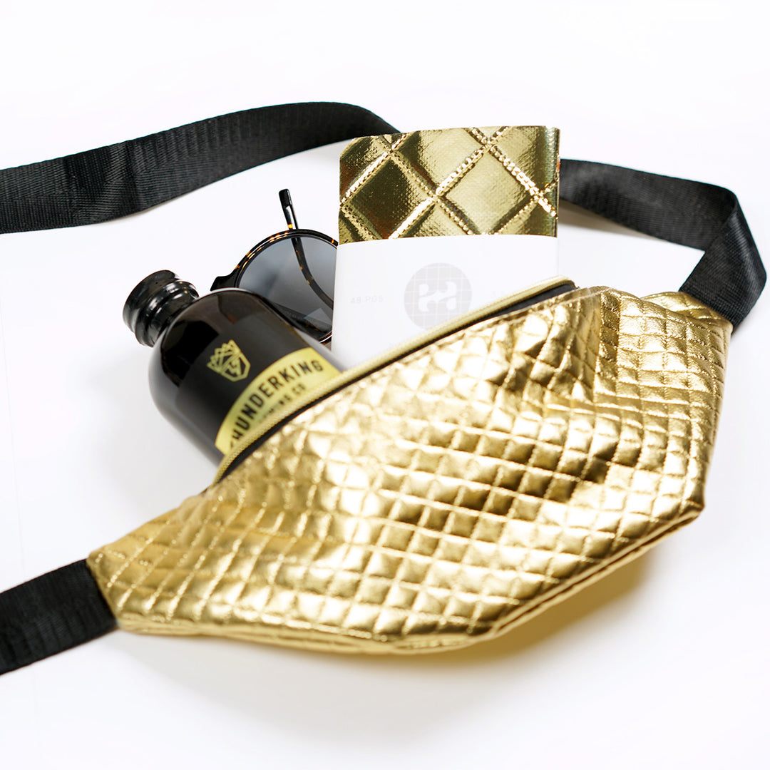 Chanel Gold Quilted Patent Leather Fanny Pack Bag with a matching notebook, coffee bottle, and warby parkers