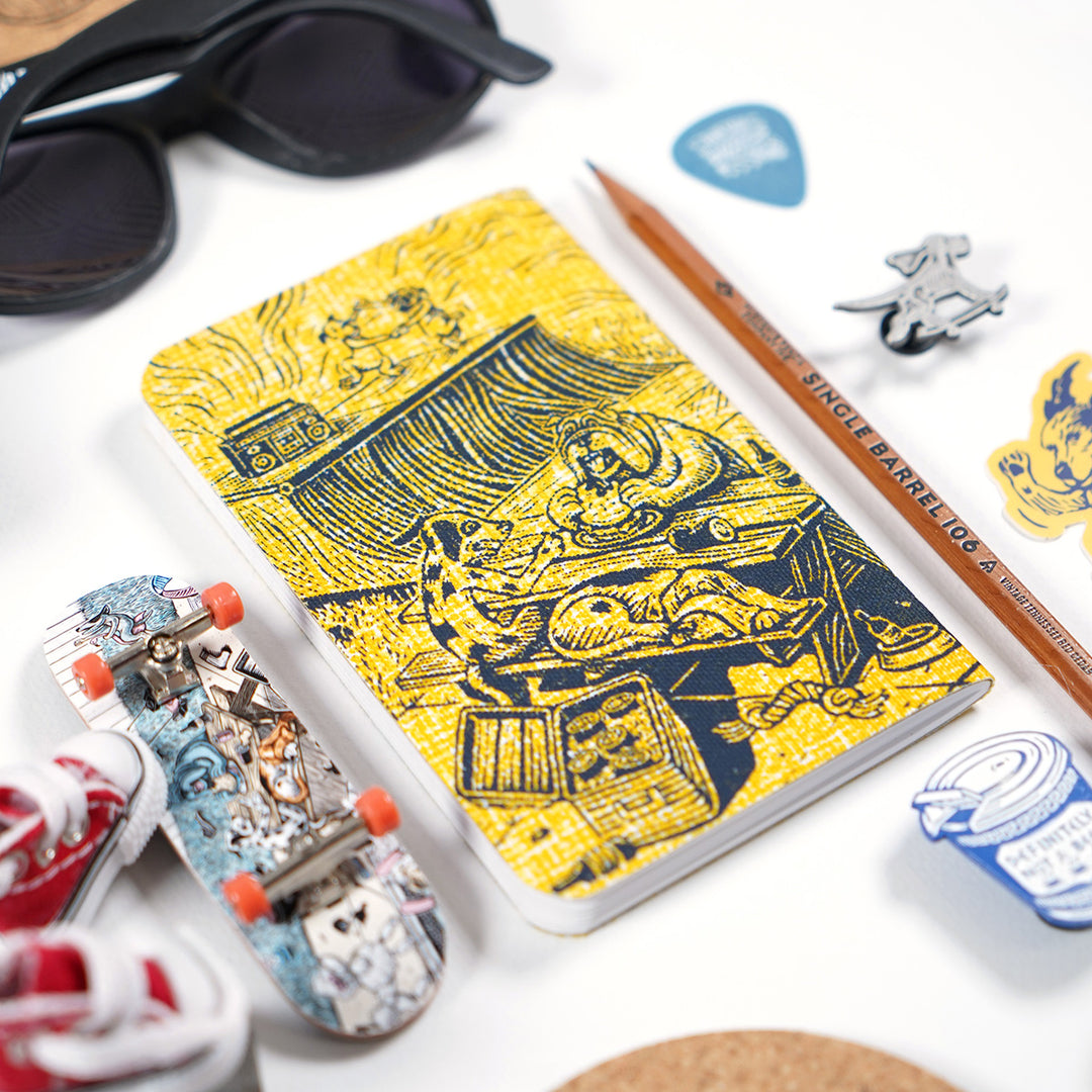 back cover of dylan goldberger's dog gone summer pocket notebook design. surrounded by vghc sunglasses, a musgrave single barrel 106 pencil, and other tchotchkes