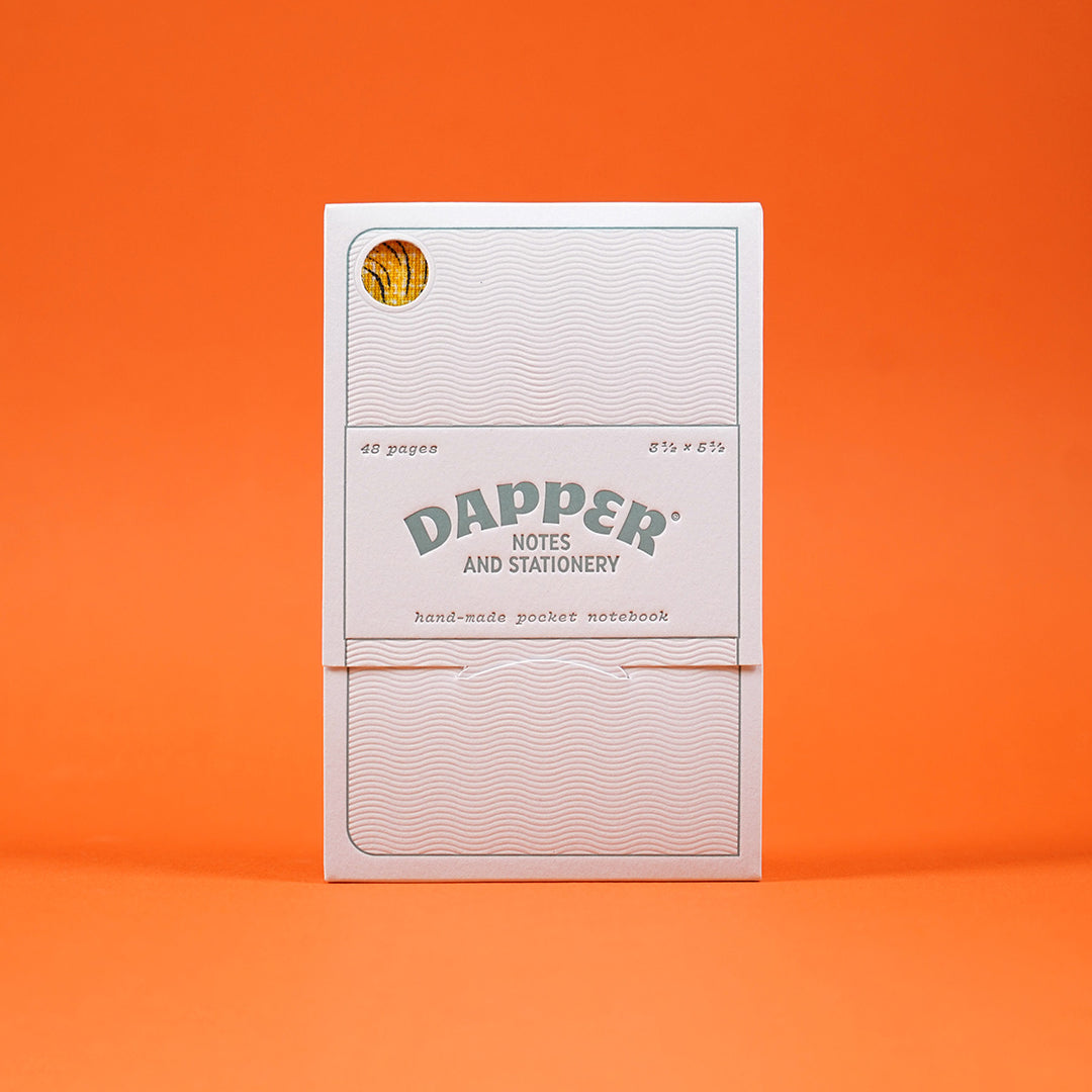 letterpress notebook packaging by mama's sauce for dapper notes, featuring dylan goldberger's notebook inside, visible through a small cutout